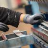 Ein Mitarbeiter bedient in der Produktionshalle einer Firma eine Metallpresse. Der Arbeitsmarkt hat sich auch im November positiv weiterentwickelt.