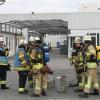 Atemschutzgeräteträger der Feuerwehr rüsten sich für ihren Einsatz in der Produktionshalle bei Moll-Batterien in Bad Staffelstein aus.