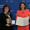 Gisela Raab (li.) erhält aus der Hand von Landtagspräsidentin Ilse Aigner die Bayerische Verfassungsmedaille in Silber.