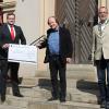 Sparkassenleiter Michael Schmelzer, Intendant des Fränkischen Theatersommers Jan Burdinski und Erster Bürgermeister Jürgen Kohmann (v. li.) bei der Scheckübergabe vor dem Rathaus.