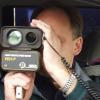 Ein Polizist kontrolliert mit dem Radarmessgerät die Geschwindigkeit. Ein Polizist kontrolliert mit dem Radarmessgerät die Geschwindigkeit.