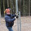 Herbert Kunzelmann schließt den Zaun, der die jungen Bäume vor Wildverbiss schützt. Herbert Kunzelmann schließt den Zaun, der die jungen Bäume vor Wildverbiss schützt.