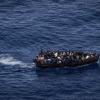Migranten steuern ein Boot in Richtung der Insel Lampedusa.
