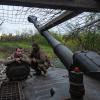 Ukrainische Soldaten schauen aus einer Panzerhaubitze.