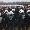 Polizisten und Demonstranten stehen sich bei der Demonstration von Klimaaktivisten am Rande des Braunkohletagebaus bei Lützerath gegenüber.