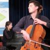 In der Internationalen Musikbegegnungsstätte „Haus Marteau“ in Lichtenberg im Landkreis Hof arbeiteten bis vor wenigen Tagen junge Cellistinnen und Cellisten im Meisterkurs des Celloprofessors Jakob Spahn. Die hochbegabten Talente aus Deutschland, Europa und Südkorea lernten und übten ihre Technik und den Ausdruck ihres Spiels zu verfeinern. Zum Ende des Kurses reisten sie nach Kutzenberg, um ihre Ergebnisse zu präsentieren.   Mit Schumann, Bach, Brahms, Beethoven, Dvorak und Elgar hatten sich die neun Künstlerinnen und Künstler herausragende Komponisten des 18. bis 20. Jahrhunderts ausgesucht. Mit einer beeindruckenden Vorstellung im Festsaal des Bezirksklinikums spielten sich die Cellisten in die Herzen der Zuhörer. Manche Stücke wurden als Solo gespielt, manche begleitete die Japanerin Mana Oguchi meisterhaft am Flügel.  Der Dozent des Meisterkurses, Professor Jakob Spahn, begleitete seine Schülerinnen und Schüler zum Konzertabend. Im Bereich der klassischen Musik ist er kein Unbekannter: Jakob Spahn schloss sein Studium an der Hanns-Eisler-Hochschule für Musik in Berlin mit dem „Solistendiplom mit Auszeichnung“ ab. Im Anschluss an seine zweijährige Zeit als Stipendiat der „Karajan-Akademie“ bei den Berliner Philharmonikern wurde er 2011 Solocellist der Bayerischen Staatsoper in München. Spahn lehrt als Professor an der Musikhochschule Nürnberg.  Er ist Preisträger zahlreicher nationaler und internationaler Wettbewerbe und wurde 2010 beim ARD-Wettbewerb mit dem Sonderpreis der „Alice-Rosner-Foundation“ ausgezeichnet.   Der Bezirk Oberfranken mit seinem Verwaltungsleiter Ulrich Wirtz war stolz darauf, einen dieser Meisterkurse zu einem Konzert als Gast zu haben: „Diese Woche ist und war Meisterkurs“, freute sich Ulrich Wirtz auf die folgenden knapp zwei Stunden. „Ich bin nicht das erste Mal im Haus Marteau“, begrüßte auch ein fröhlicher und bestens gelaunter Jakob Spahn die Klassik-Liebhaber im Festsaal. „Es beginnt mit Schumann und hört mit Schumann auf“, lud er die Gäste auf eine musikalische Reise ein.  Die Teilnehmer seines Meisterkurses präsentierten in Kutzenberg ein Konzert auf Spitzenniveau. Es spielten Antonio Lorente Garcia, Henrike Körner, Lukas Hrncarek, Leyre Barros, Johannes Kaiser, Anselm Siebelitz, Mathilde Heise, Franz Hofereiter und Kim Minyoung auf ihren Celli.   Das Cello – auch als Violoncello bekannt – entstand nach 1535 in Norditalien und wird mit einem Bogen gestrichen, selten auch mit dem Finger gezupft. Es ist ein aus verschiedenen Holzarten gefertigtes Streichinstrument. Ein Cello wird in der Regel auf einem Stachel stehend zwischen den Beinen des Cellisten im Sitzen gespielt. Das Besondere an diesem Streichinstrument mit seinen vier Saiten ist einerseits der weiche und vielfältige Klang, andererseits der große Tonumfang von mehreren Oktaven.