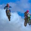 Waghalsiges Überholmanöver während eines Sprunges bei einer Motocross-Veranstaltung.