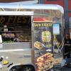 Glänzender Anblick mit glänzenden Aussichten - ein Food Truck auf dem Marktplatz. Glänzender Anblick mit glänzenden Aussichten - ein Food Truck auf dem Marktplatz.