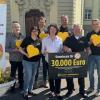 Edeka-Mitarbeiter überreichten einen symbolischen Scheck an die Verantwortlichen des Würzburger Vereins Kiwi: Erste Reihe von links: Stefanie Schmitt (Edeka), Ina Schmolke (Vorsitzende Kiwi), Detlef Kautzmann (Edeka), Stefan Schwab (Edeka).  Zweite Reihe von links: Urban Hübner (Kiwi), Prof. Dr. Christoph Härtel (Kinderklinik), Stefan Knötgen (Edeka).