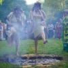 Frauen springen beim Beltane-Festival am Glastonbury Chalice Well in England über das Feuer.