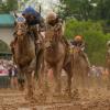 Good Cheer, geritten von Luis Saez, links, steuert auf die Ziellinie zu, um das 151. Kentucky Oaks Pferderennen in Churchill Downs in Louisville, Kentucky, zu gewinnen. Nach Regenfällen über der Rennbahn ist das Geläuf sehr matschig geworden.