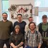 Gruppenbild vor der neuen Skulptur in der Cafeteria: (Vorne von links) die Teilnehmenden Leonie Winkler und Nikolaos Andreadis, (hinten von links) Tobias Streun vom sozialpädagogischen Fachdienst, die Teilnehmenden Dominik Schalk und Nikolai Wozniak sowie Ausbilder Lukas Feyh. Auf dem Foto fehlt Teilnehmer Paul Otterbach.