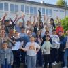 Mitglieder des Elternbeirats übergeben Geldumschläge für alle Siedlungskinder an die Klasse 4d.