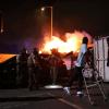 Ein Mann blickt auf ein Feuer, nachdem ihm die Strafverfolgungsbehörden während einer Demonstration aus einem Auto geholfen haben. Die Bundeseinwanderungsbehörden haben Operationen durchgeführt.