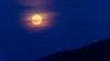 Der Rauch von den Waldbränden in Kanada lässt den Vollmond orange-rötlich erscheinen.