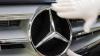 Ein Mercedes-Stern wird an einer Motorhaube befestigt.