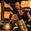 Feuerwehrmänner sitzen in Lörrach nach ihrem Einsatz auf einer Bank.