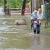 Ein Mutter watet mit ihrer Tochter durch die vom Fluss Kabelske überflutete Straße im Ortsteil Gröbers der Gemeinde Kabelsketal.