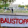 Auf einem Protestplakat im Schlossgarten in Stuttgart fordern Gegner des milliardenschweren Bahnprojekts Stuttgart 21 am Dienstag (05.10.2010) einen Baustopp. Im Hintergrund steht der Südflügel des Bahnhofs, der neben dem bereits abgerissenen Nordflügel ebenfalls weichen soll.