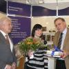 Sabrina Janzer aus Ötigheim ist 20.000. Besucherin der Karlsruher Bücherschau 2011. Von Johannes Scherer (rechts) erhielt sie ein Buchpaket, von Regierungspräsident Dr. Rudolf Kühner einen Blumenstrauß.