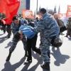 Polizisten nehmen in Moskau einem Teilnehmer einer kommunistischen Mai-Demonstration fest.