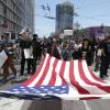 Demonstranten in San Francisco marschierten mit einer großen US-Flagge. Demonstranten in San Francisco marschierten mit einer großen US-Flagge.