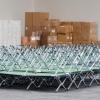 Feldbetten sind in einer Messehalle aufgestapelt. Foto: Julian Stratenschulte/Archiv