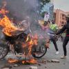 Demonstranten stehen vor einem brennenden Motorrad während einer Demonstration gegen die Regierung aus Anlass des Todes eines populären Bloggers in Polizeigewahrsam in Kenia.