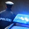 Ein Polizist steht vor einem Streifenwagen.