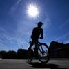 Ein Radfahrer fährt in der Sonne über einen Radweg.
