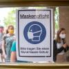 Schüler betreten hinter einem Plakat mit der Aufschrift «Maskenpflicht» am ersten Tag nach den Sommerferien den Eingang zum Rheingau Gymnasium in Berlin. Schüler betreten hinter einem Plakat mit der Aufschrift «Maskenpflicht» am ersten Tag nach den Sommerferien den Eingang zum Rheingau Gymnasium in Berlin.