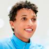 Die Leichtathletin Malaika Mihambo sitzt während eines Gesprächs in dem Fitnessraum eines Sponsors.