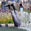 Aus einem Brunnen ragen zwei Beine mit Gummistiefeln hervor.