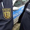 Polizisten neben einem Polizeifahrzeug.