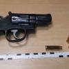 Ein Revolver und Munition die sichergestellt worden waren, liegen neben Maßbändern auf einem Tisch.