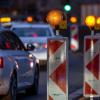 Autos stehen am Abend im Stau an einer Baustelle.