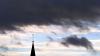 Hinter dem Turm der Pfarrkirche St.Cornelius ziehen Wolken.