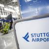 Fluggäste gehen mit ihrem Gepäck zu Check-In-Schaltern.