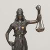 Eine Figur «Justitia» steht auf einem Schreibtisch.
