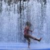Abkühlung: Ein Kind spielt in einem Springbrunnen in London, während ungewöhnliche Hitze in der britischen Hauptstadt herrscht.