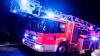 Ein Drehleiterwagen der Feuerwehr fährt mit Blaulicht über eine Straße.