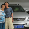 Jianyi Wan und Zhenjiang Hu vor dem Auto, mit dem sie über 11.000 Kilometer nach Deutschland gereist sind. Warum die beiden nicht denselben Namen haben? In China ist es nicht üblich, das Frauen den Namen des Mannes annehmen.