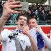 KSC-Spieler Marvin Pourie (r) posiert nach Spielende mit einem Fan für ein Selfie. Mit einem 4:1 bei Preußen Münster hat der Karlsruher Sport-Club den Aufstieg in die 2. Fußball-Bundesliga vorzeitig perfekt gemacht.
