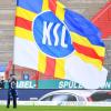 Ein Karlsruher Fan schwenkt vor Spielbeginn vor leeren Zuschauerrängen eine Fahne mit der Aufschrift "KSC".