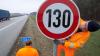 Ein Verkehrsschild mit Tempolimit 130 wird auf der Autobahn montiert.