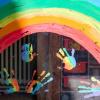 Kinderhände und ein Regenbogen sind durch eine Scheibe zu sehen. Kinderhände und ein Regenbogen sind durch eine Scheibe zu sehen.