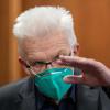 Mit einem grünen Mund-Nasen-Schutz spricht Winfried Kretschmann (Bündnis 90/Die Grünen), Ministerpräsident von Baden-Württemberg.