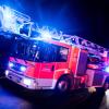 Ein Drehleiterwagen der Feuerwehr mit Blaulicht.