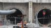 Bauarbeiter stehen vor dem Eingang des Bahntunnels.