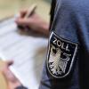 Ein Zollbeamter füllt einen Personalerfassungsbogen aus.